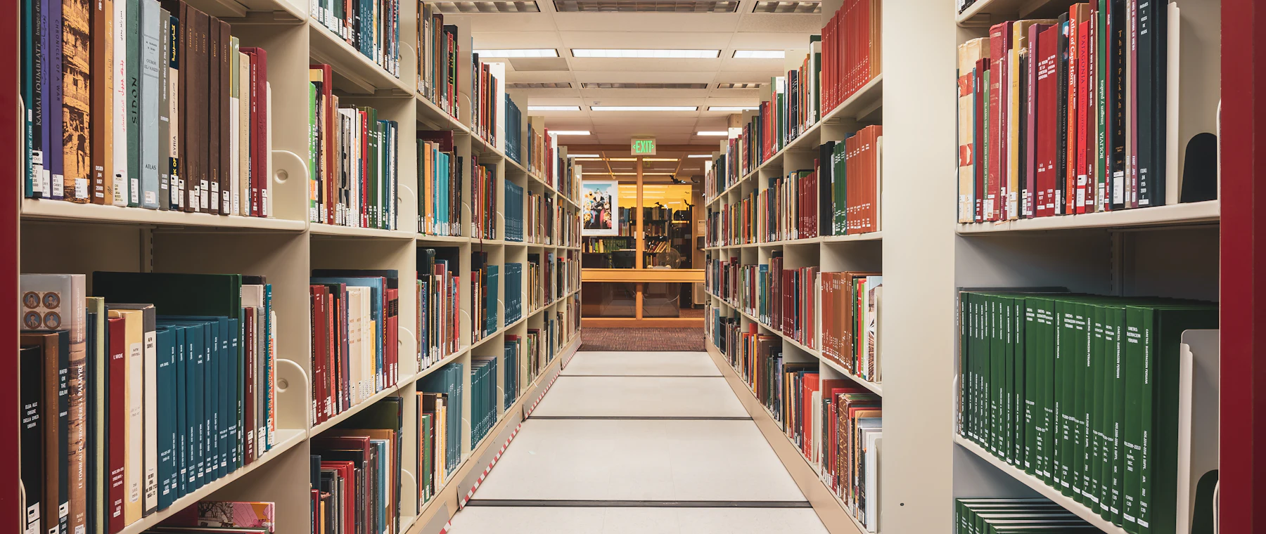 Longue allée entre les rayonnages d’une bibliothèque
